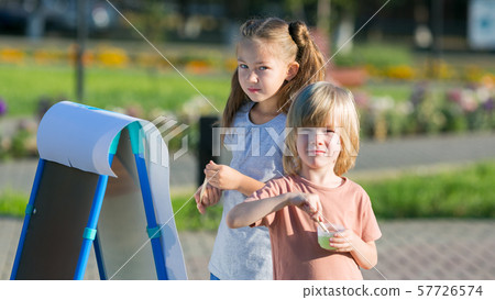 Brother and sister are painting on the street 57726574