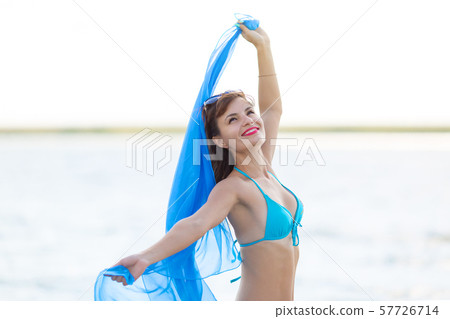 Girl on the pier with a blue scarf 57726714