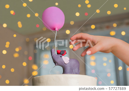 Delicious cake for one year old birthday. Cake for family holidays. Childs hand and cake decorated 57727889