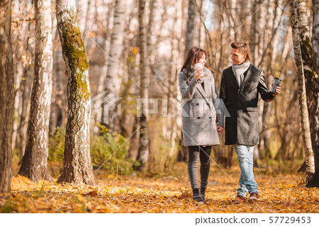 Happy family walking in autumn park on sunny fall day Happy family walking in autumn park on sunny fall day 57729453