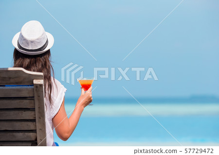 Beautiful young woman relaxing at beach chairs Beautiful young woman relaxing at beach chairs 57729472