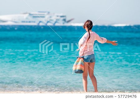 Young girl on the beach background big cruise liner. Woman enjoy her wekeend on one of the beautiful Young girl on the beach background big cruise liner. Woman enjoy her wekeend on one of the beautiful 57729476