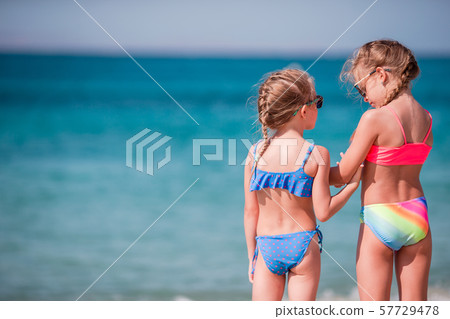 Two little happy girls have a lot of fun at tropical beach playing together Two little happy girls have a lot of fun at tropical beach playing together 57729478
