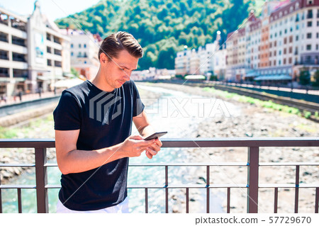 Man on the embankment of a mountain river in a European city. 57729670
