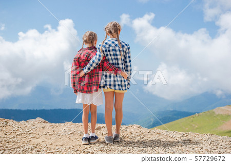 Beautiful happy little girls in mountains in the background of fog Beautiful happy little girls in mountains in the background of fog 57729672