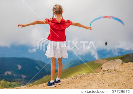Beautiful happy little girl in mountains in the background of fog 57729675