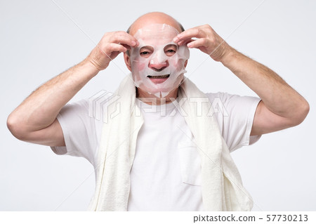 Hispanic mature man in a cosmetic mask skin care Hispanic mature man in a cosmetic mask skin care 57730213