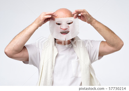 Hispanic mature man in a cosmetic mask skin care 57730214