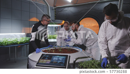 Scientists examining seedlings on Mars base Scientists examining seedlings on Mars base 57730288