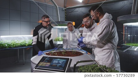 Scientists examining seedlings on Mars base Scientists examining seedlings on Mars base 57730289