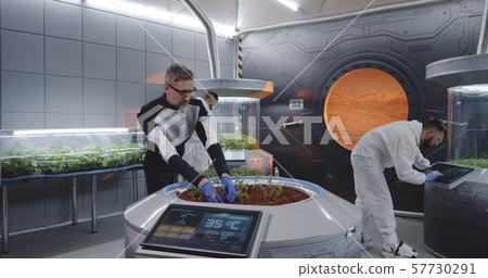 Scientist planting seedlings on Martian base Scientist planting seedlings on Martian base 57730291