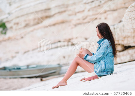 Woman laying on the beach enjoying summer holidays looking at the sea Woman laying on the beach enjoying summer holidays looking at the sea 57730466