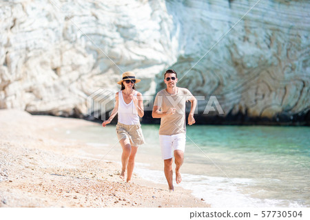Lovely couple walking on the beach and enjoying summer vacation Lovely couple walking on the beach and enjoying summer vacation 57730504