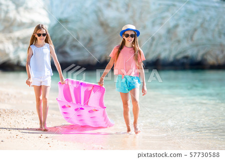 Little girls having fun at tropical beach during summer vacation playing together 57730588