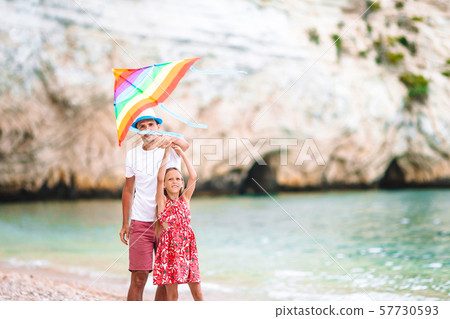 Family flying kite together at tropical white beach Family flying kite together at tropical white beach 57730593