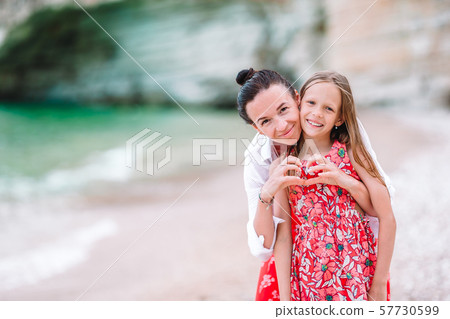 Beautiful mother and daughter at the beach enjoying summer vacation. Beautiful mother and daughter at the beach enjoying summer vacation. 57730599