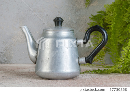 Silver metal tea pot on concrete background. 57730868