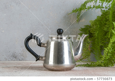 Silver metal tea pot on concrete background. 57730873