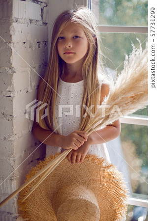 girl in the straw hat stands at the window girl in the straw hat stands at the window 57731299