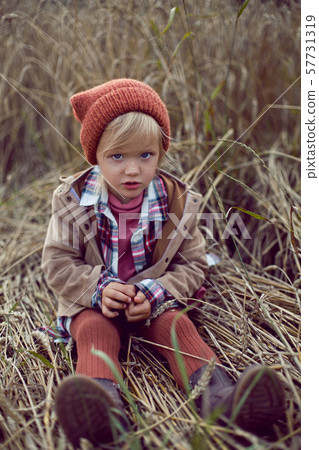 baby girl sitting in a warm orange hat baby girl sitting in a warm orange hat 57731319