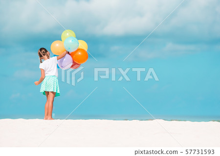 Adorable little girl playing with balloons at the beach Adorable little girl playing with balloons at the beach 57731593