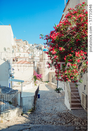 The narrow streets of the island with blue balconies, stairs and flowers. 57731646