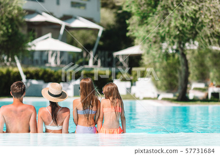 Happy family of four in outdoors swimming pool 57731684
