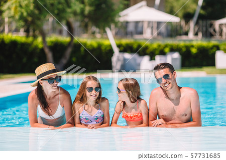 Happy family of four in outdoors swimming pool 57731685