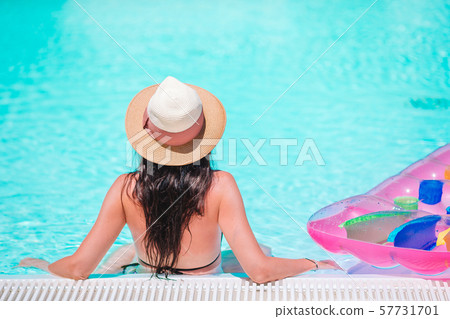 Beautiful young woman relaxing in swimming pool. Beautiful young woman relaxing in swimming pool. 57731701