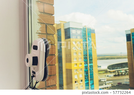 Vacuum cleaner robot cleaning window in high building outdoor. Vacuum cleaner robot cleaning window in high building outdoor. 57732264
