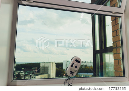 Vacuum cleaner robot cleaning window in high building outdoor. Vacuum cleaner robot cleaning window in high building outdoor. 57732265