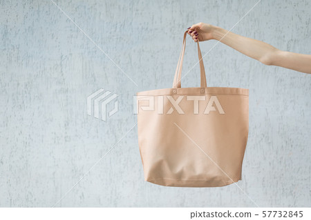 Large eco shopping bag in the hand of a young Large eco shopping bag in the hand of a young 57732845