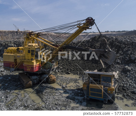 Huge industrial dump truck in a stone quarry loaded transporting marble or granite shot from a drone 57732873
