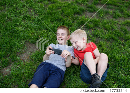 Two boys with a smartphone in their hands having Two boys with a smartphone in their hands having 57733244