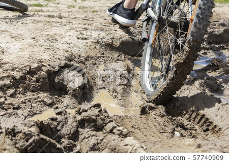 the Bicycle wheel is stuck in the mud. Close up 57740909