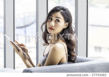 Beautiful woman sitting and shopping online with 57743083