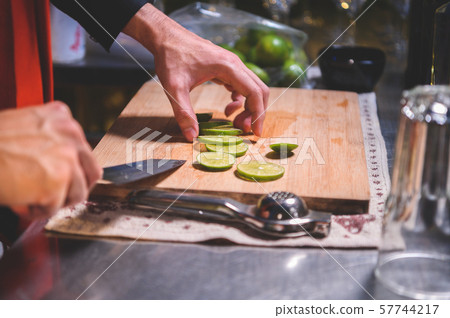 Closeup of professional bartender hand slicing Closeup of professional bartender hand slicing 57744217