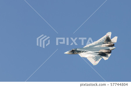 A military blue and whote fighter jet flying in the sky A military blue and whote fighter jet flying in the sky 57744804