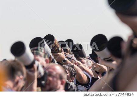 Photographers taking photos of an airplanes - lenses pointing up 57744924