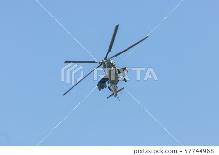 A military helicopter flying in the blue sky A military helicopter flying in the blue sky 57744968
