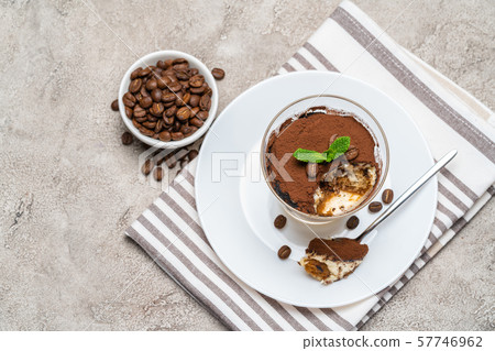 Portion of Classic tiramisu dessert in a glass cup on concrete background 57746962