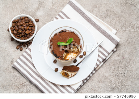 Portion of Classic tiramisu dessert in a glass cup on concrete background 57746990