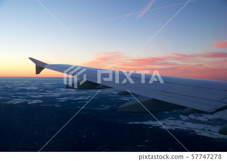FRANKFURT, GERMANY - JAN 20th, 2017: View on the sunset, germany during winter and airplane wing FRANKFURT, GERMANY - JAN 20th, 2017: View on the sunset, germany during winter and airplane wing 57747278