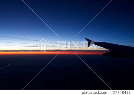 FRANKFURT, GERMANY - JAN 20th, 2017: View on the sunset, germany during winter and airplane wing FRANKFURT, GERMANY - JAN 20th, 2017: View on the sunset, germany during winter and airplane wing 57748421