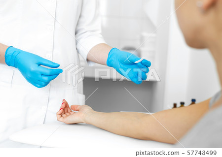 The girl prepared a hand for blood sampling from The girl prepared a hand for blood sampling from 57748499