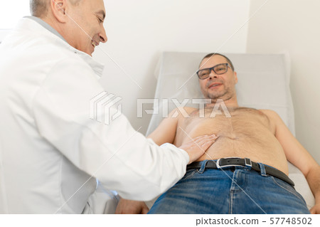 Doctor physiotherapist examining his patients Doctor physiotherapist examining his patients 57748502