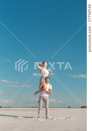 Romantic couple dancing in sand desert at blue sky Romantic couple dancing in sand desert at blue sky 57748548