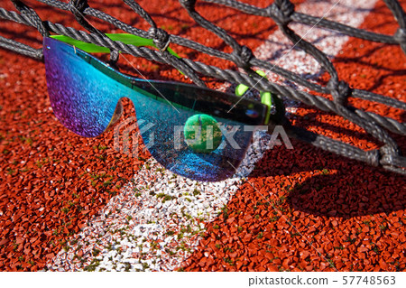 Sunglasses and ball on a tennis racket Sunglasses and ball on a tennis racket 57748563