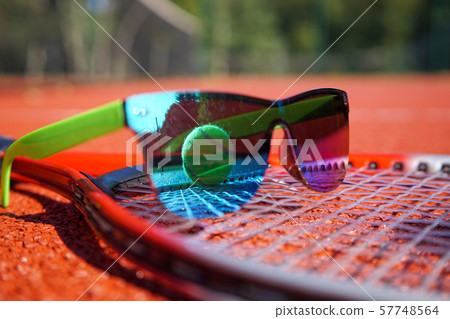 Sunglasses and ball on a tennis racket Sunglasses and ball on a tennis racket 57748564