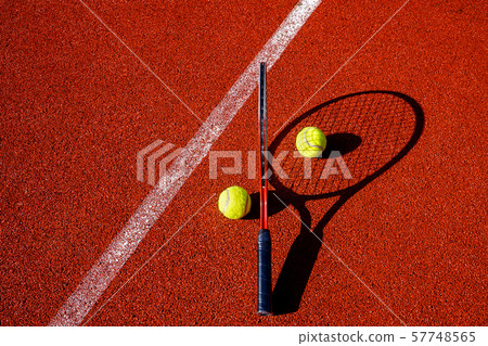 Tennis balls and racket on an outdoor court Tennis balls and racket on an outdoor court 57748565